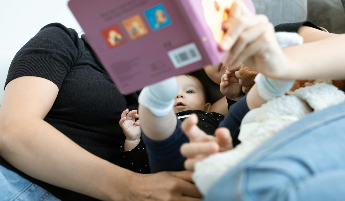 A baby and family reading together, promoting love and education. Cozy indoors setting.